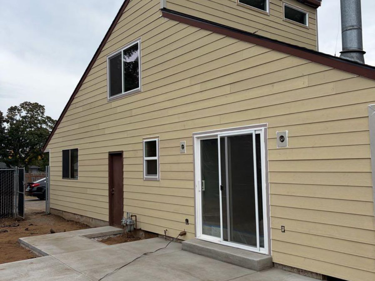 Home exterior with new siding, sliding door and new concrete patio